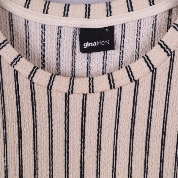 Närbild på Gina Tricot-etikett på klänningsinsida