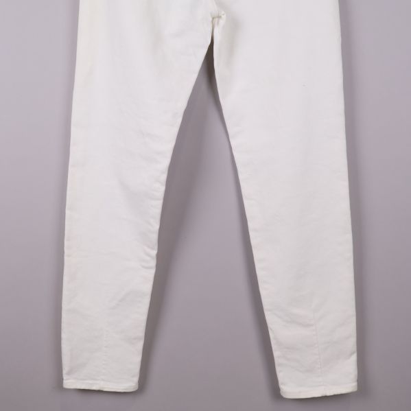 Närbild på benen av vita jeans