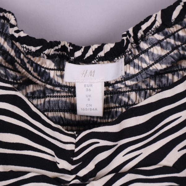 Närbild på blusens storleksetikett med H&M logga