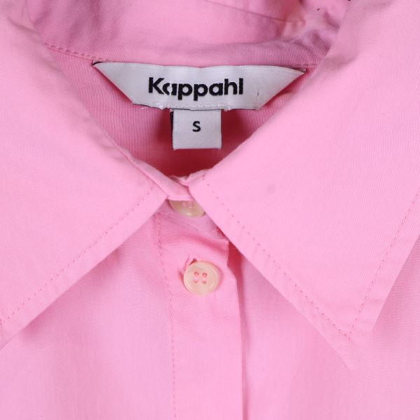 Kappahl märkning och svart knapp på rosa skjorta