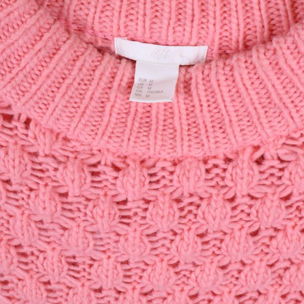Närbild av hals och etikett på rosa tröja
