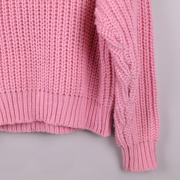 Närbild på ärmen av rosa stickad tröja