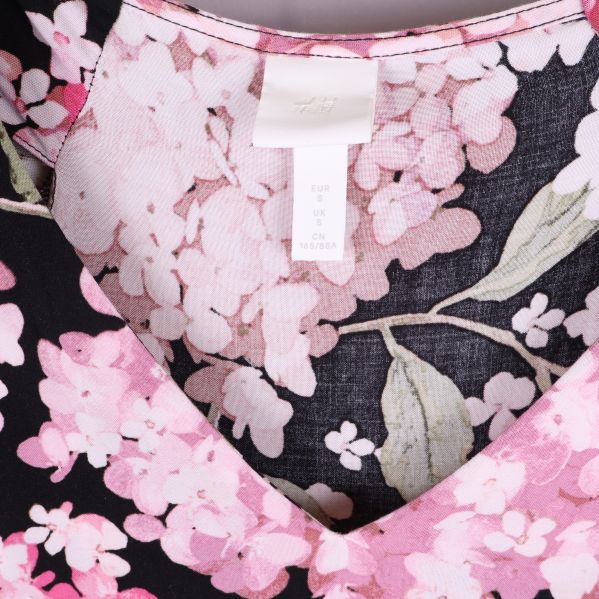 Närbild av klänningens V-ringning och blommönster