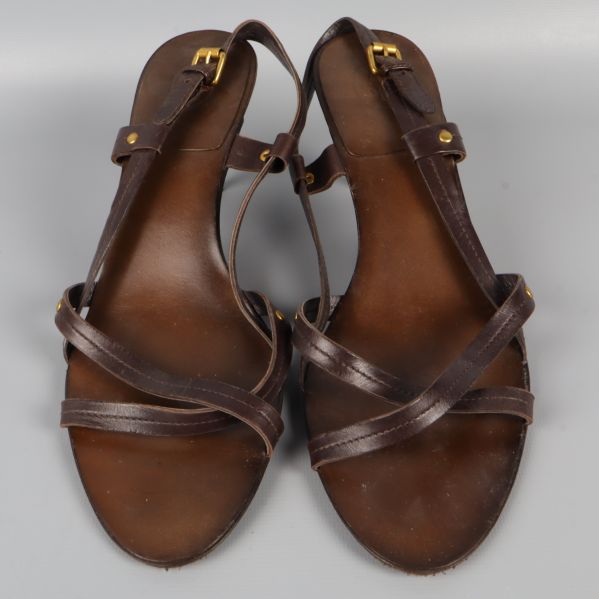 Sida av bruna klackskor med remmar