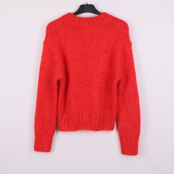 Stickad röd tröja sedd bakifrån med ribbade muddar