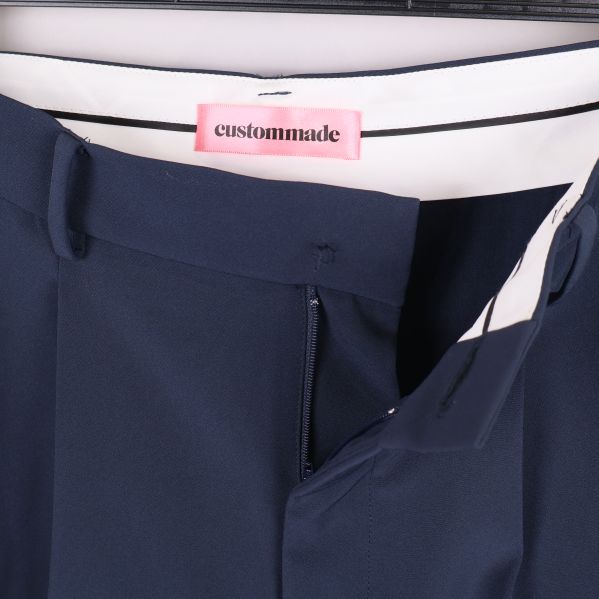 Byxans insida med synlig etikett och Custommade-logga