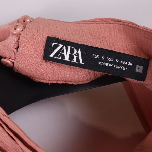 Zara-etikett på insidan av gammelrosa blus