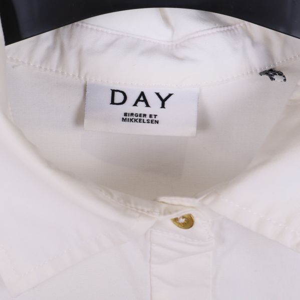 Närbild på vit skjortkrage med DAY-märke