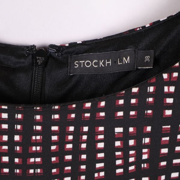 Närbild på klänningsetikett med varumärket STOCKH LM