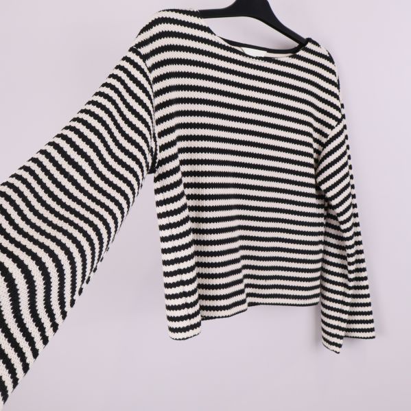 Stickad tröja med vid ärm i fokus och randigt mönster