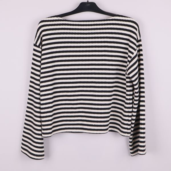 Stickad tröja med svarta och vita horisontella ränder bakifrån