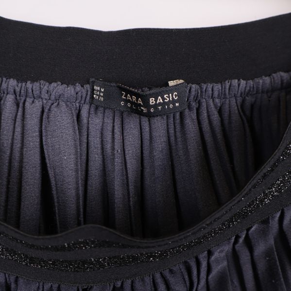 Närbild på svart resår och Zara Basic-etikett inuti kjolen