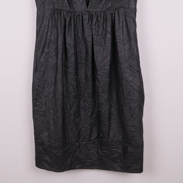 Närbild på nederdelen av klänningen med strukturerat tyg