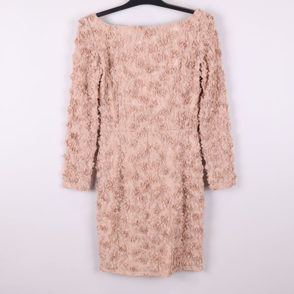 Baksidan på beige klänning med blommiga detaljer