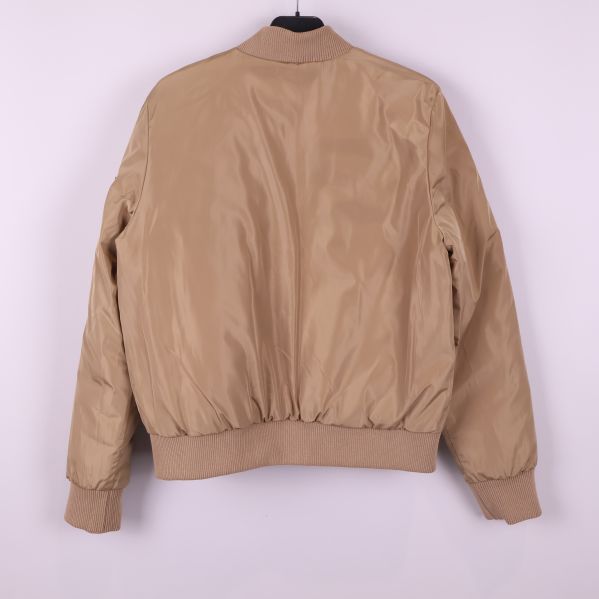 Slät baksida av beige bomberjacka med ribbad nederkant