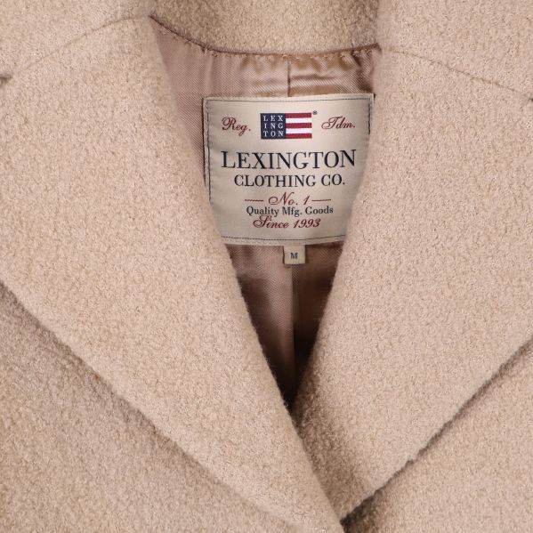 Närbild av etiketten Lexington Clothing Co vid kappans krage