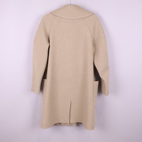 Baksida av beige kappa visar längd och ryggdetalj