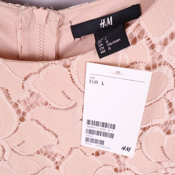 Närbild på H&M-etikett och storlekslapp vid halsringningen