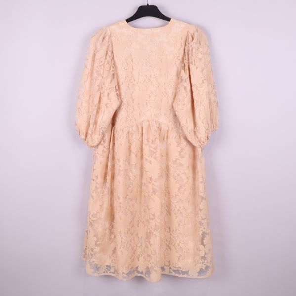 Helbild av beige klänning med puffärmar och blommigt mönster bakifrån