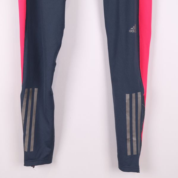 Nederdel av ben med reflekterande Adidas-detaljer vid anklarna