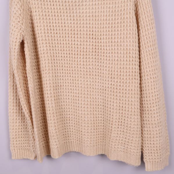 Nedre delen av stickad polotröja i beige