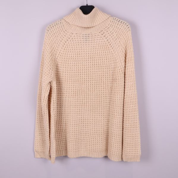 Stickad beige polotröja på galge bakifrån