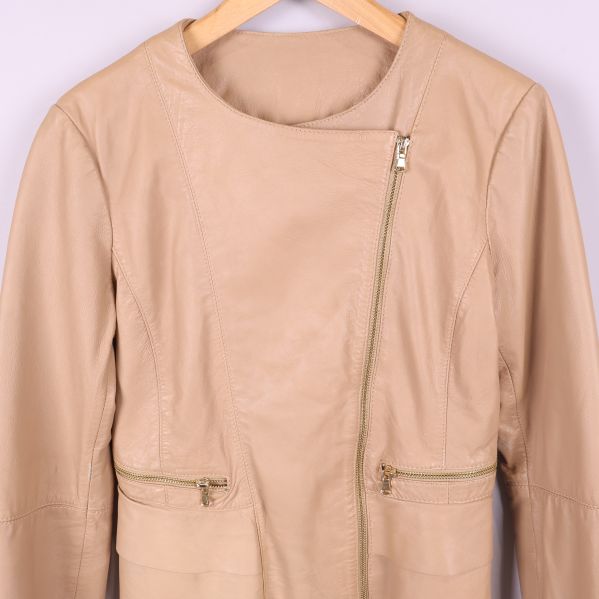 Närbild av jackans framsida och dragkedja i beige skinn