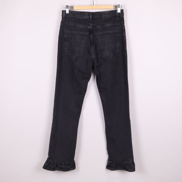 Svarta jeans med volangkant upphängda bakifrån