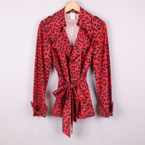 Framsida av röd leopardmönstrad jacka på galge