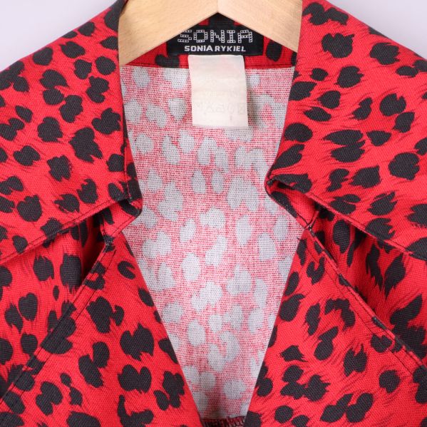 Närbild på etikett och krage i röd leopardmönstrad jacka