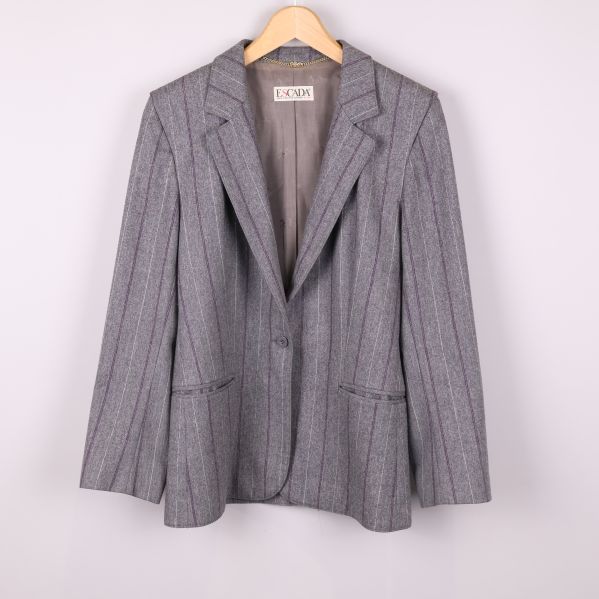 Grå kavaj med kritstrecksrandigt mönster hängande på galge