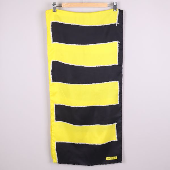 Lång svart och gul scarf på galge