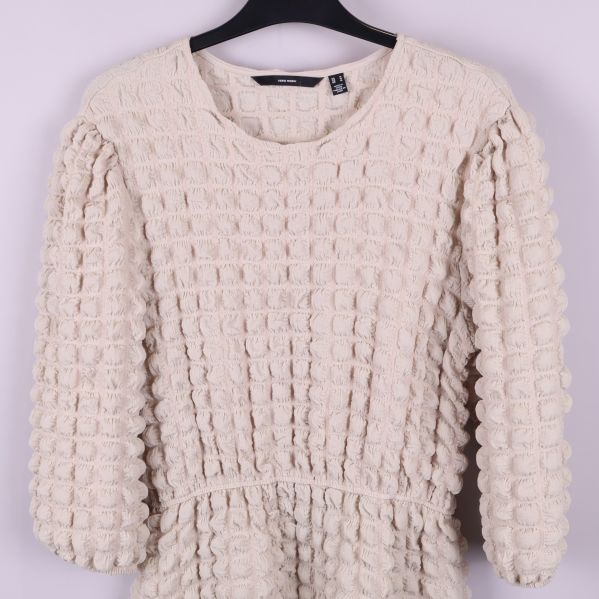 Närbild på klänningens strukturerade mönster och tyg