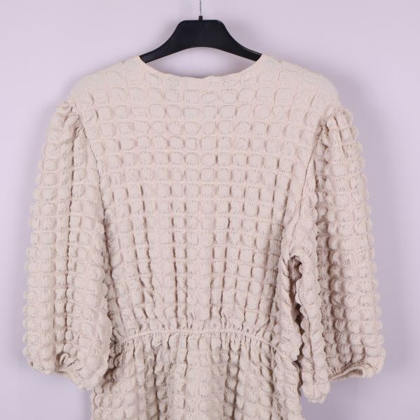 Baksida av klänningen nära visar tygstruktur