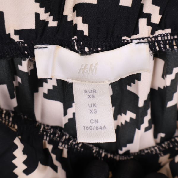 Närbild på storleksetikett från H&M med XS-märkning