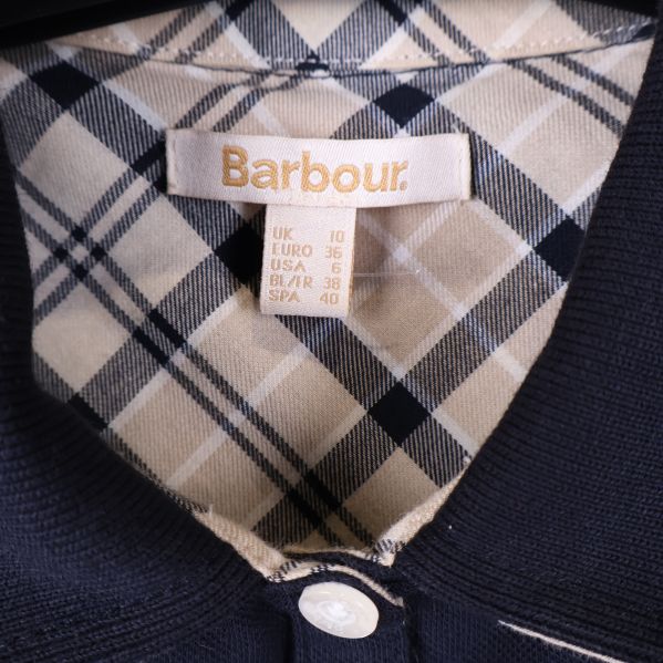 Barbour etikett och rutigt foder i kragen på pikétröjan