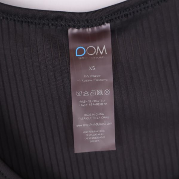 Närbild materiallapp DOM XS 90% polyester 10% elastan