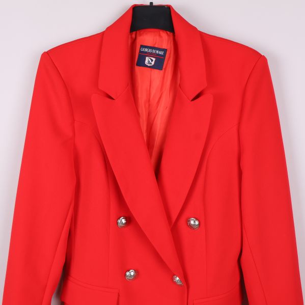 Närbild på axel och övre delen av röd kavaj