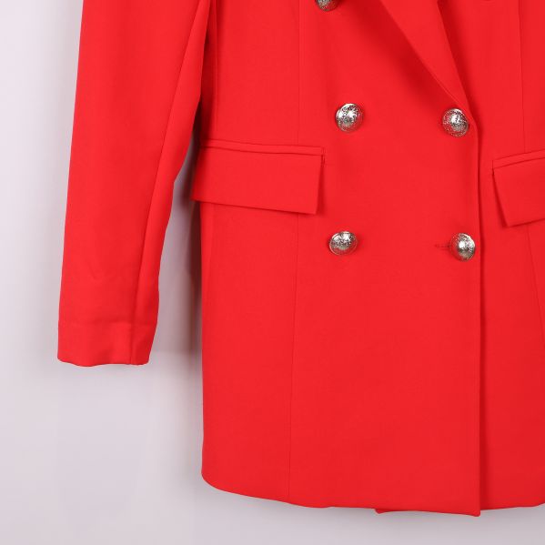 Närbild på fickor och knappar på röd kavaj