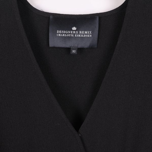 Närbild på Designers Remix-logga i nacken på klänning