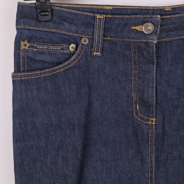 Närbild på fickor, knapp och sömmar av jeanskjolen