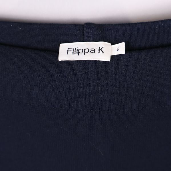 Närbild på Filippa K-logotyp och storleksetikett insydd i kjolen