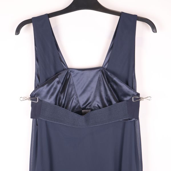 Närbild på foder och axelband på blå klänning