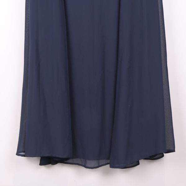 Nederdel av blå lång klänning visas i närbild