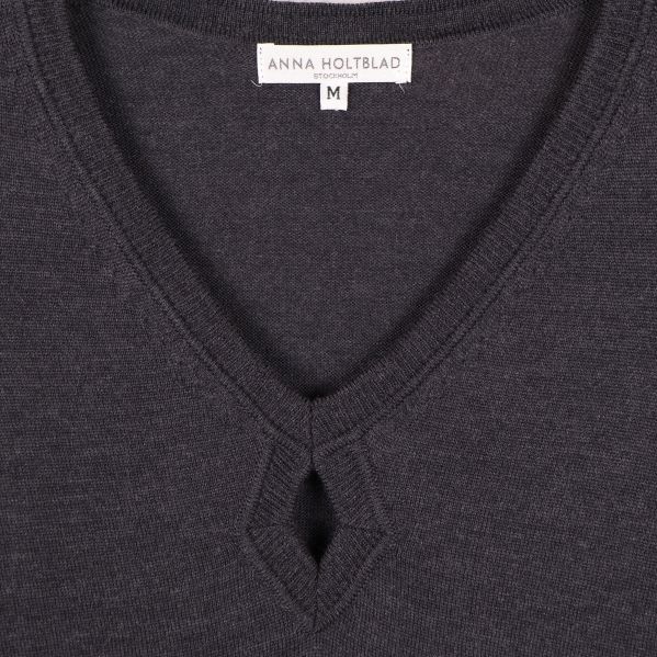 Närbild av V-ringning och droppdetalj samt märkesskylt Anna Holtblad