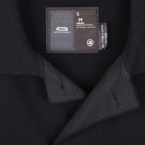 Närbild på etikett och krage av svart kofta