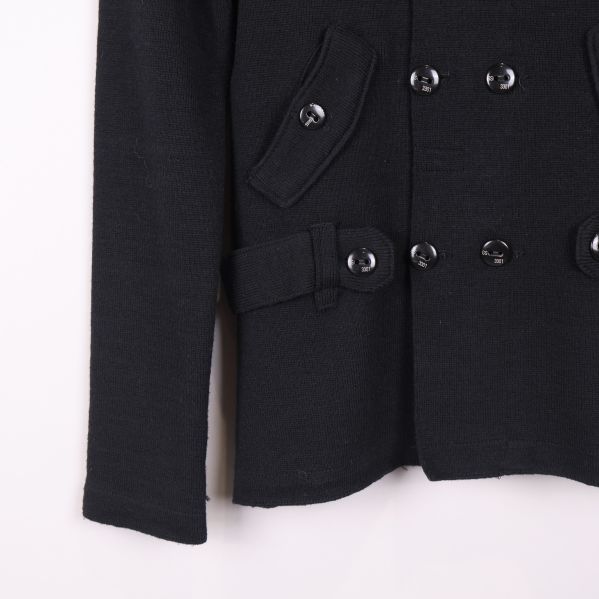 Nedre delen av svart kofta med fickor och bälte