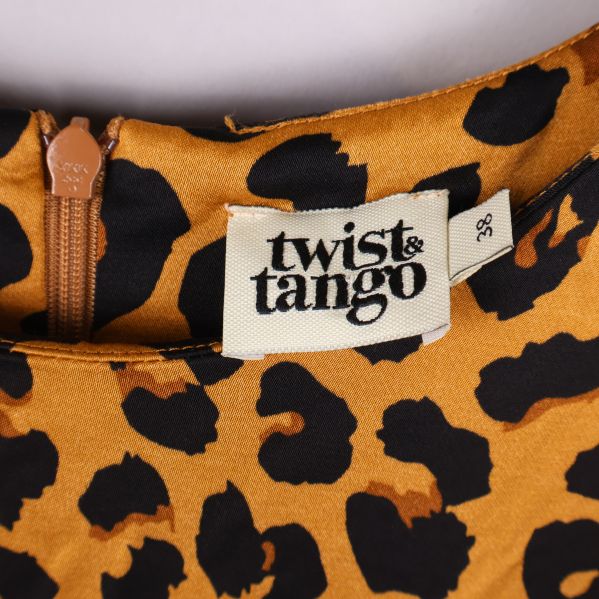 Närbild av Twist & Tango-etikett vid hals på leopardtopp
