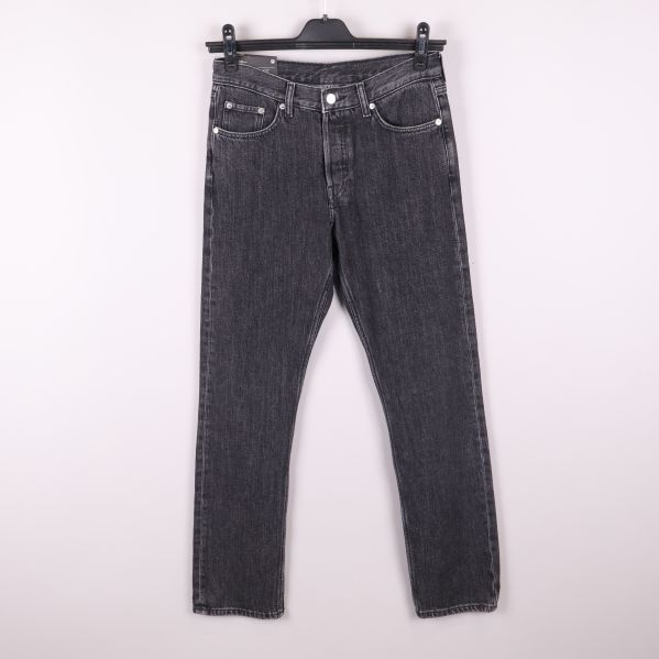 Svarta jeans hängande på galge mot ljus bakgrund