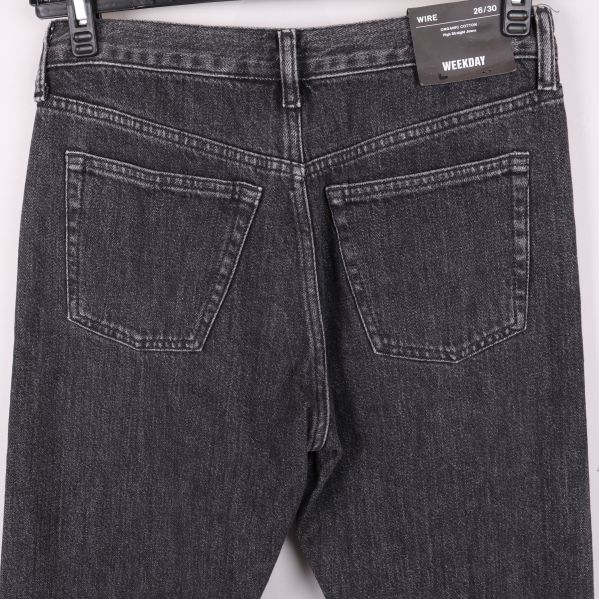 Närbild av bakfickor och linning på svarta jeans